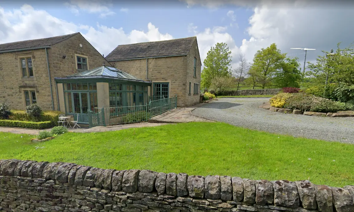 Before: plain lawn and gravel drive beside the stone cottage