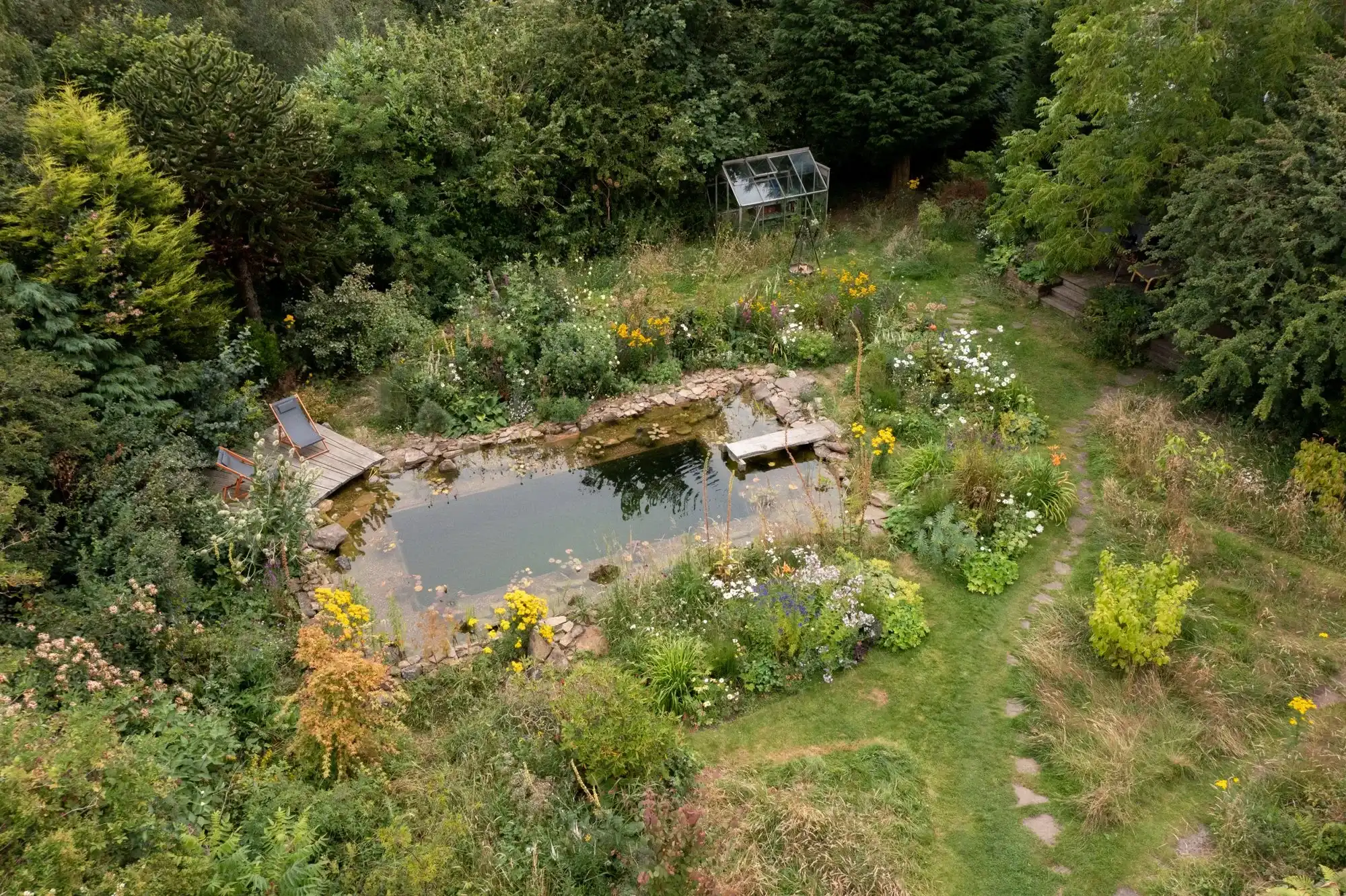 Aerial view of a wildlife pond garden with stone edging, deck and wildflower planting